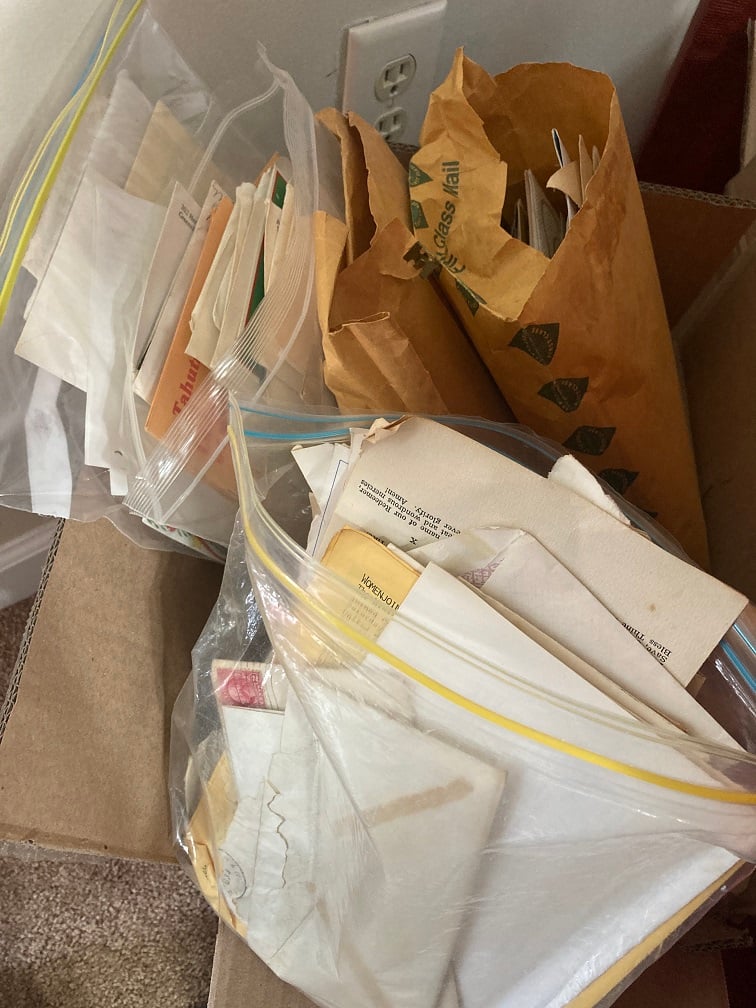 a cardboard box filled with large zip lock bags of old letters