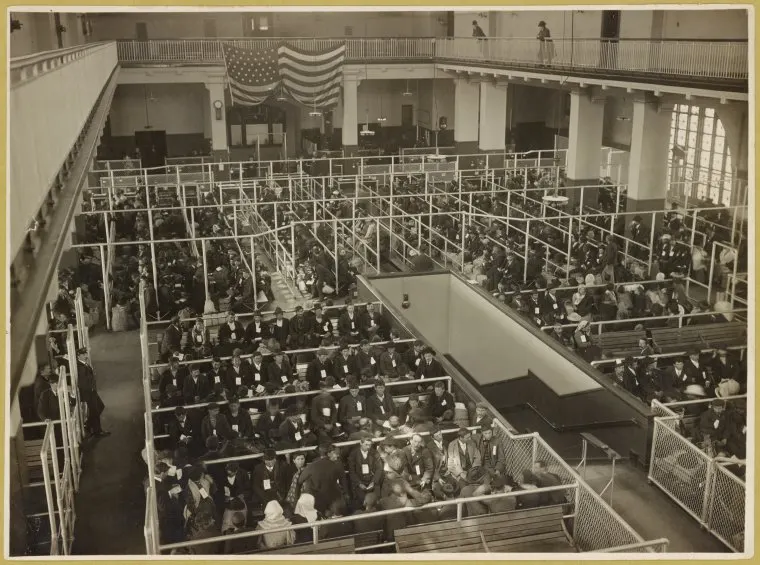 An early 1900s photograph taken from a high vantage point that shows the entire great room where immigrants were lined up for inspections and interviews